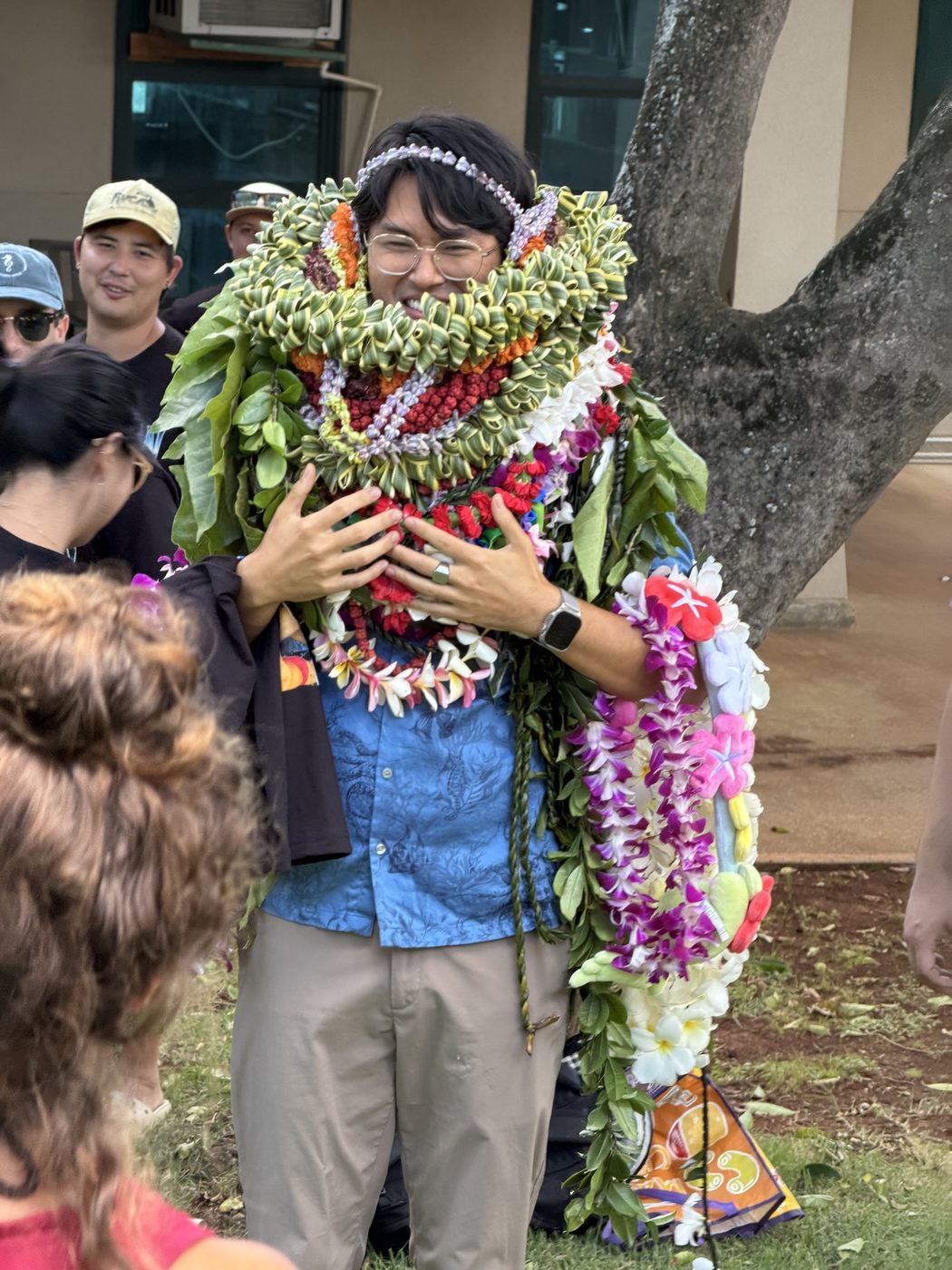 Dr. Leon Tran buried in lei after his Ph.D. defense